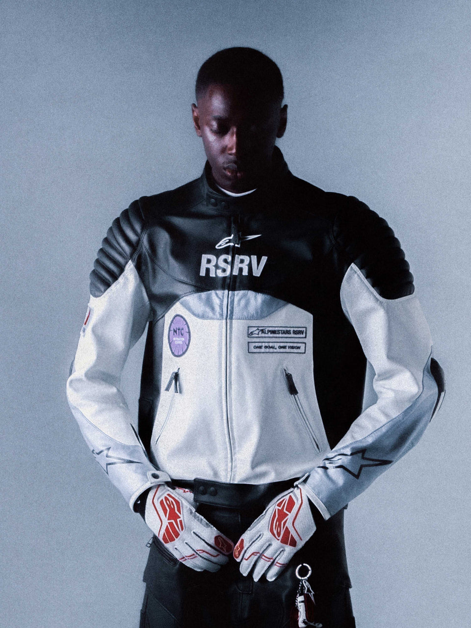 Alpinestars RSRV Threadline Leather Jacket, Premium Motorcycle Jacket, Black and White, Padded Shoulders, RSRV Branding, Luxury Streetwear Collection, Worn with White and Red Gloves, Dramatic Studio Lighting